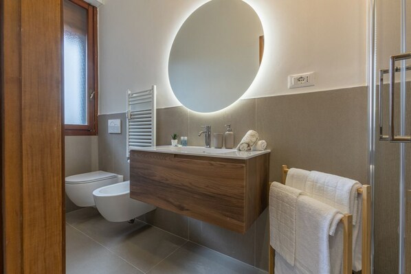 Een douche, een haardroger, een bidet, handdoeken