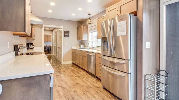 A modern kitchen with stainless steel appliances, wooden cabinets, and a marble countertop. - 1 Mi to Oregon Dunes: Quiet Getaway w/ Deck (Lakeside)