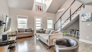A spacious living room with a high ceiling, a staircase, and a view of the outdoors. - 1 Mi to Oregon Dunes: Quiet Getaway w/ Deck (Lakeside)
