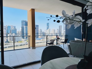 Enjoy a panoramic city view from the balcony, featuring a seating area with a sofa and chairs.