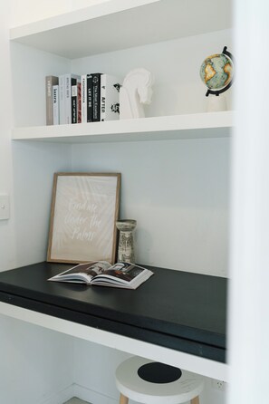 A bookshelf with books, a framed quote, and a globe.