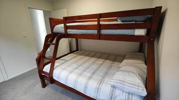 A bunk bed with a wooden frame and striped bedding.