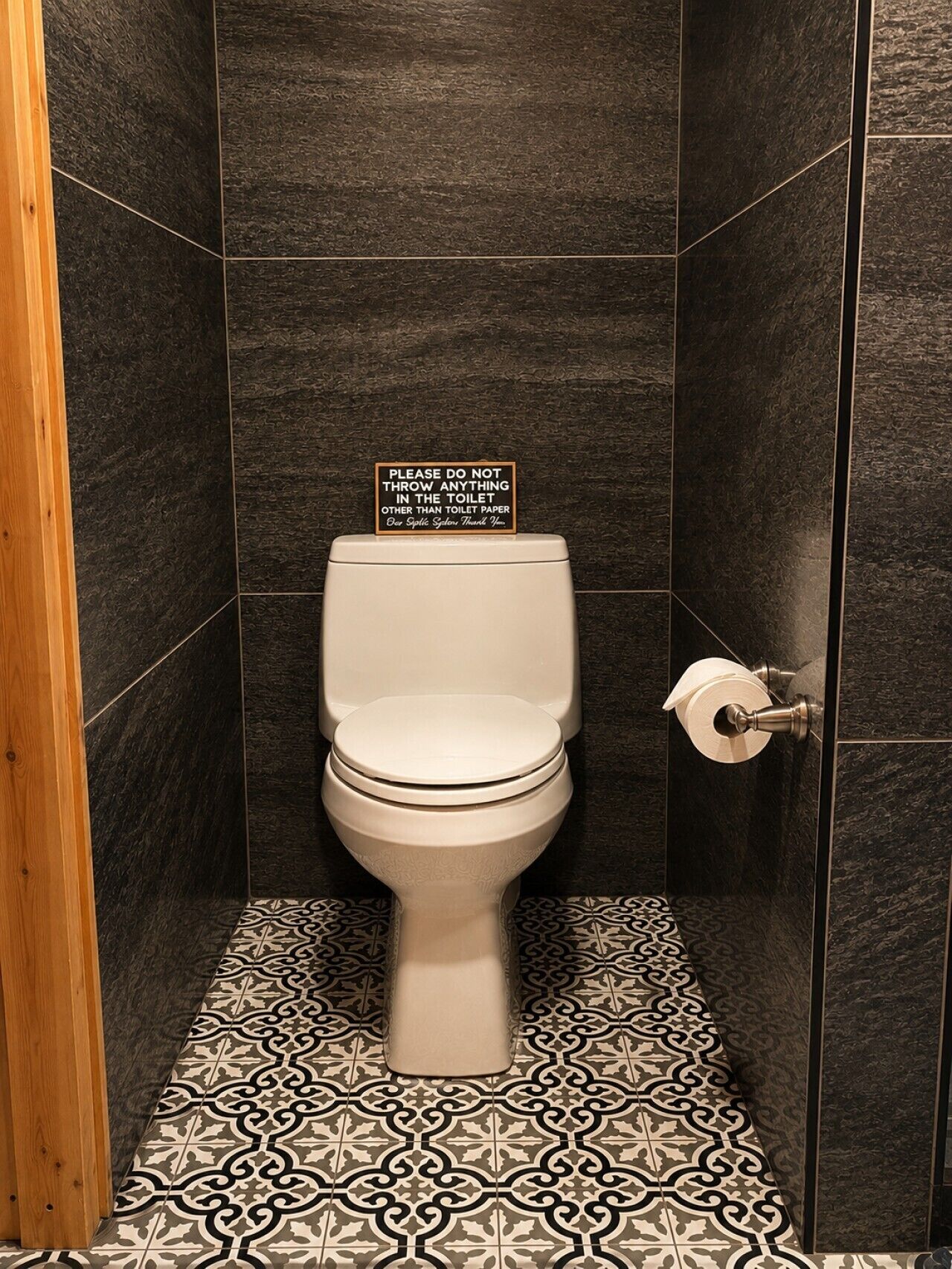 A toilet with a sign instructing not to throw anything other than toilet paper.