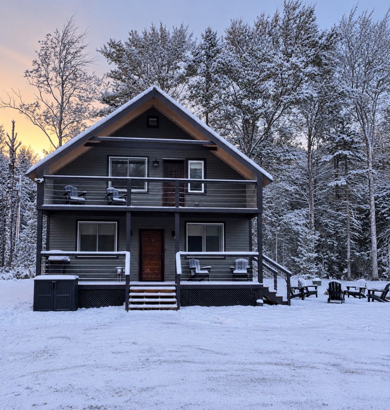 A two-story cabin with a front porch, a staircase, and a deck with chairs.