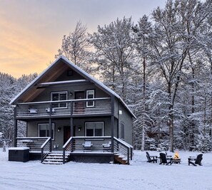 A two-story cabin with a balcony, surrounded by snow-covered trees. - The MountainTop | Stratton & Mt Snow | Fire Pit (Stratton)
