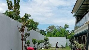 A paved walkway with hexagonal tiles leading to a building. - Laika Homestay (Banguntapan)