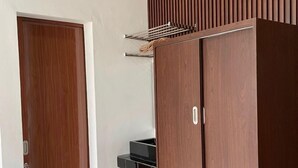 A room with a wardrobe, a door, and an air conditioning unit. - Laika Homestay (Banguntapan)