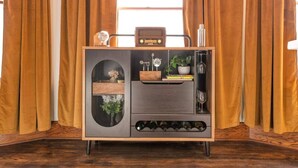 A wooden cabinet with a radio, a wine rack, and decorative items.