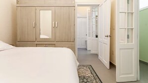 A bedroom with a bed, a wardrobe, and a door leading to a hallway. - Amazing Apartment in Condesa (Ciudad de México)