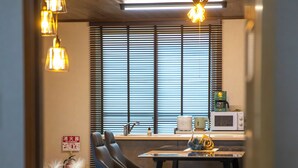 Una cucina moderna con zona pranzo, caratterizzata da un soffitto in legno, un tavolo con sedie e un forno a microonde.