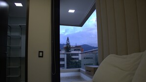 A bedroom with a balcony, a bed, and a shelving unit. - 1002 - Beautiful Apartment In El Poblado Medellin (Medellín)