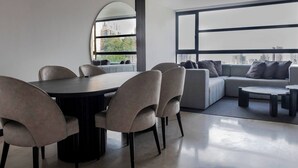 A modern living room with a dining area, large windows, and a city view. - 1002 - Beautiful Apartment In El Poblado Medellin (Medellín)