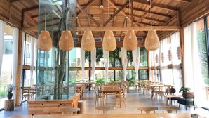 A spacious indoor area with wooden tables and chairs, large windows, and hanging woven light fixtures. - Yingde YeDuGu Resort (Qingyuan)