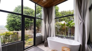 A modern bathroom with a freestanding bathtub, large windows, and a view of a garden. - Yingde YeDuGu Resort (Qingyuan)