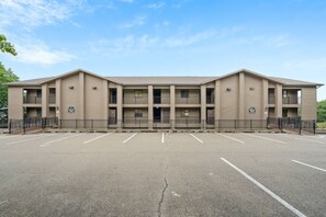 A multi-story building with a parking lot in front.