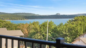 A view of a lake with a building on the far shore, surrounded by dense trees. - 2BD, Sleeps 8 Lake Condo, Resort Perks, Ticket/Golf Deals (Branson)