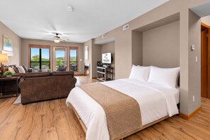 Une chambre d’hôtel avec un grand lit, un canapé, une télévision et une cheminée.