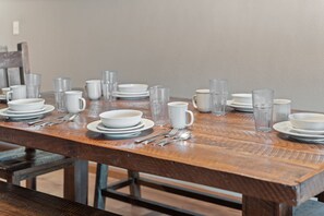 A dining table set with plates, bowls, cups, and cutlery. - Lake View Condo Near Silver Dollar City | Walk to Table Rock Lake | 2 Pools | Near 2 Marinas (Branson)
