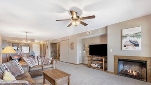 A living room with a fireplace, a television, and a ceiling fan. - Resort  Perks, Golf/Ticket Deals- Lake View - Private  Deck! (Branson)