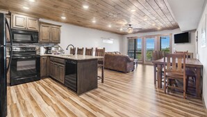 A spacious kitchen with wooden cabinets, a central island, and a dining area with a wooden table and chairs.
