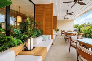 A modern indoor space with a dining area, seating, and ceiling fans. - Sea and Sun Apartments (Da Nang)