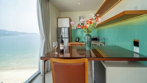 Eine moderne Küche mit Meerblick, einem Esstisch mit Stühlen und einer Vase mit Blumen.
