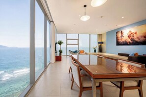 A spacious room with a large dining table, a view of the ocean, and a modern interior design. - Sea and Sun Apartments (Da Nang)