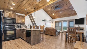 A spacious kitchen with wooden cabinets, a central island, and a dining area with a wooden table and chairs. - Sweet 3BR + Loft With Spectacular View of Lake (Branson)