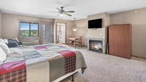 Une chambre à coucher avec un lit, une cheminée, un téléviseur et une armoire.