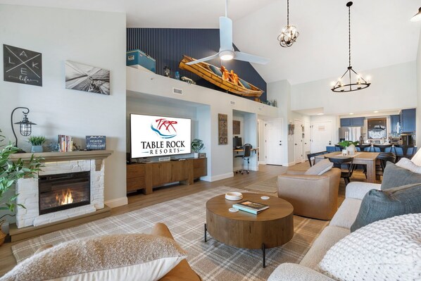 A spacious living room with a fireplace, a television, and a dining area.