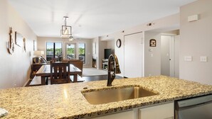 A kitchen with granite countertops, a stainless steel sink, and a modern faucet. - Incredible 1 Bd Lake Condo with Resort Perks & Ticket Discounts! (Branson)