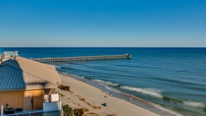 A beachside hotel with a view of the ocean and a pier. - Wake up to sweeping ocean views from the 16th floor at Oceans One (Myrtle Beach)