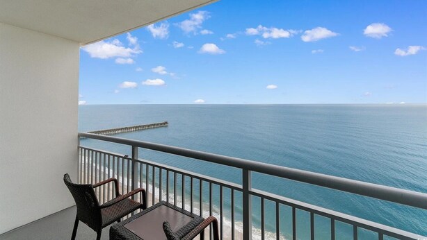 A balcony with a view of the ocean and a pier. - Wake up to sweeping ocean views from the 16th floor at Oceans One (Myrtle Beach)