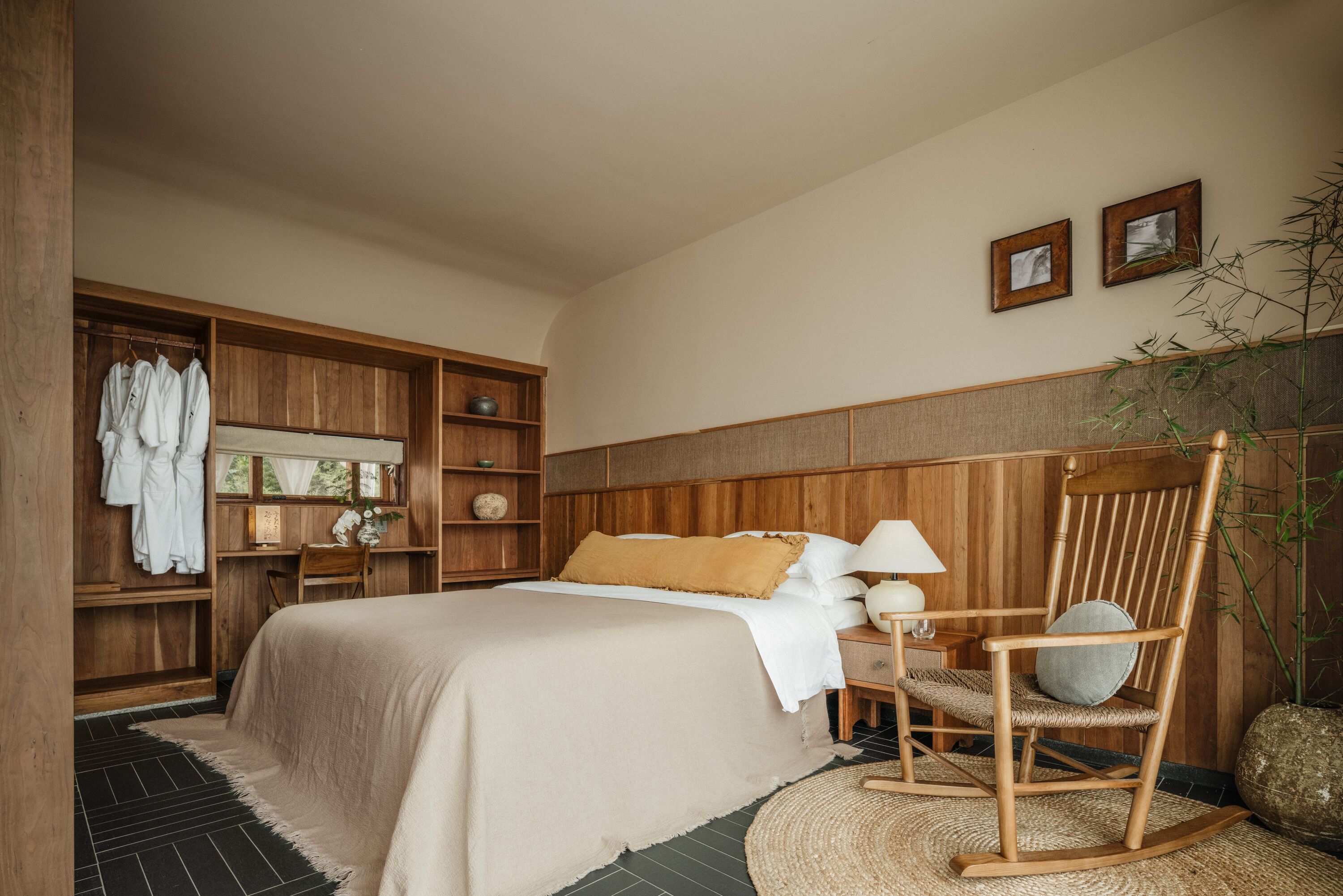 Une chambre à coucher avec un grand lit, une armoire en bois et un fauteuil à bascule.