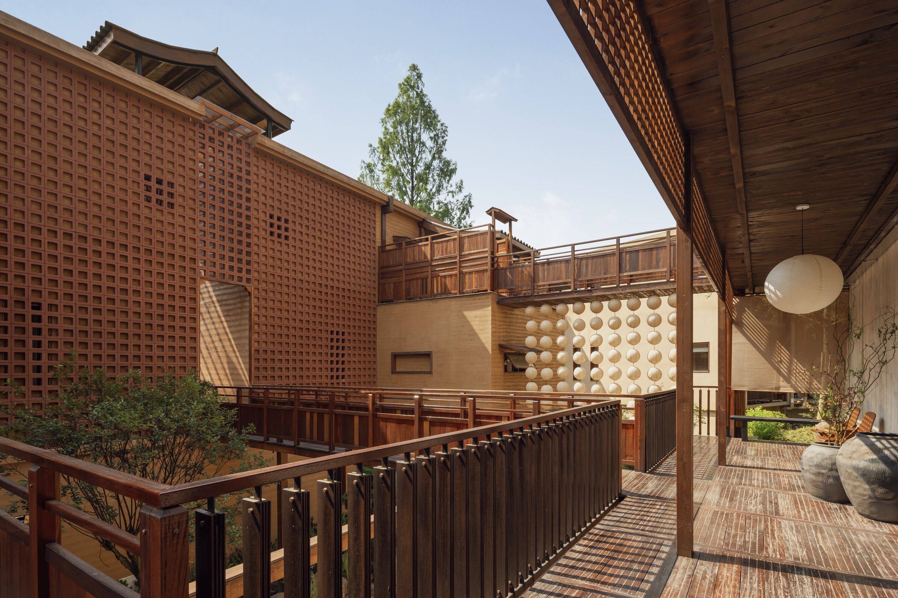 A traditional Japanese-style building with wooden lattice walls, a wooden deck, and a covered seating area.