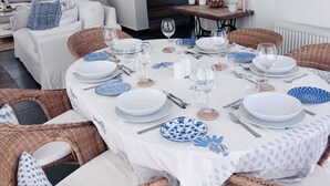 A dining area with a round table set for six, surrounded by wicker chairs. - STAY Pantheon Villa (Pissouri)