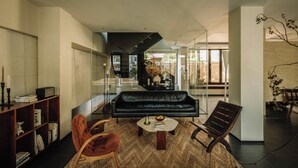 A modern living room with a black leather sofa, a coffee table, and a bookshelf. - Shine on (Suzhou)