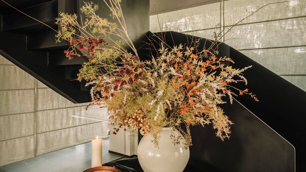 A staircase with a vase of flowers and candles on a table. - Shine on (Suzhou)