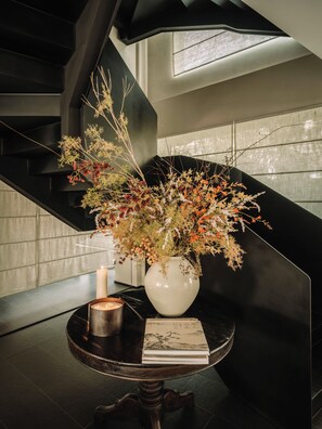 A staircase with a vase of flowers and candles on a table. - Shine on (Suzhou)