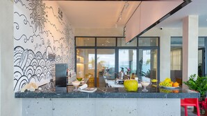 A modern kitchen with a marble countertop, a large window, and a view of the sea. - Tianya Jingxi Seaview Inn in Sanya (Sanya)