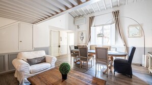 Un'ampia zona giorno con un tavolino in legno, un divano e un tavolo da pranzo con sedie.
