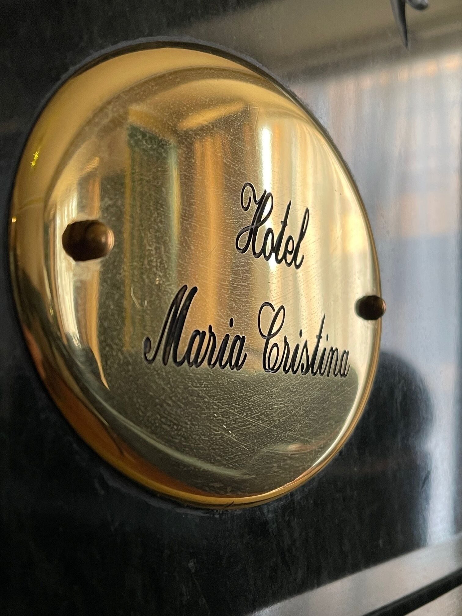 A metallic plaque with the inscription "Hotel Maria Cristina."