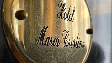 A metallic plaque with the inscription "Hotel Maria Cristina."