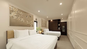 Une chambre d’hôtel avec deux lits, une grande œuvre d’art florale accrochée au mur et une armoire en bois.