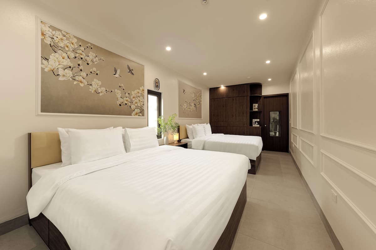 Una habitación de hotel con dos camas, una obra de arte floral grande en la pared y un armario de madera.