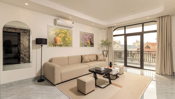 Un salon moderne avec un canapé, une table basse et des œuvres d’art accrochées au mur.