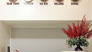 Un comptoir d’accueil avec des horloges indiquant l’heure à New York, Londres, Hanoï, Pékin et Séoul.