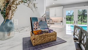 Uma cozinha com bancada de mármore, uma cesta de vime com produtos de panificação e uma placa de 'Welcome'.