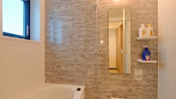Combined shower/bathtub, hair dryer, slippers, towels