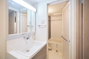 Combined shower/bathtub, hair dryer, slippers, towels